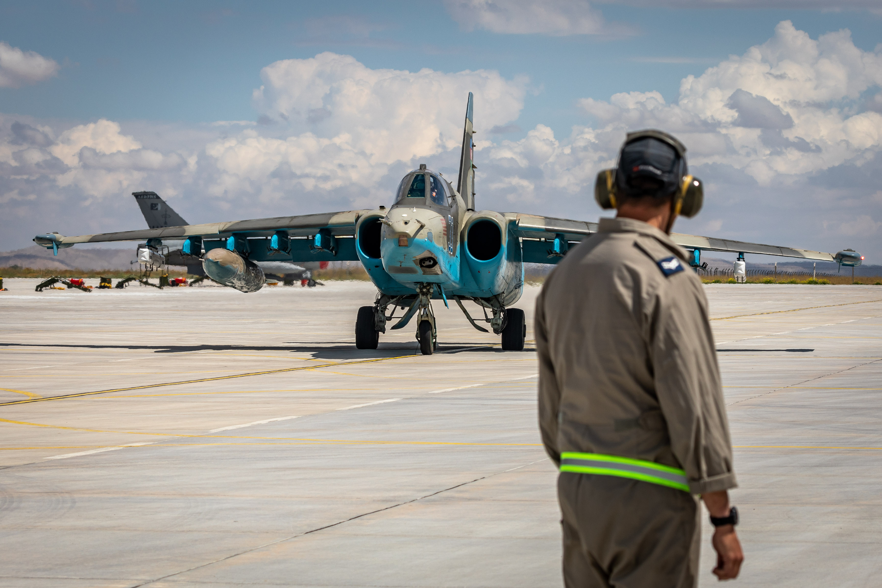 Image shows aviator looking towards Typhoon aircraft with blue painting on the airfield.